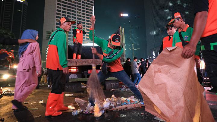 Foto: Petugas DLH Jakarta membersihkan sampah usai perayaan Tahun Baru 2025 di Bundaran HI, 1 Januari.